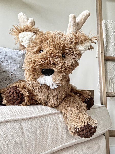 A plush deer with brown faux fur and crocheted accents.