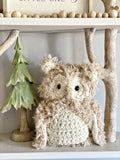 A plush owl with beige faux fur and crocheted accents.