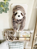 A plush Sloth Wall Mount handmade by ClaraLoo in a jungle themed nursery. This stuffed sloth is mounted on a white wooden plaque.