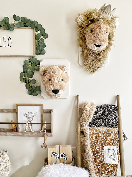 A plush Lioness Wall Mount handmade by ClaraLoo in a safari themed nursery. A stuffed Lion Wall Mount made by ClaraLoo is on the wall next to the Lioness Wall Mount.